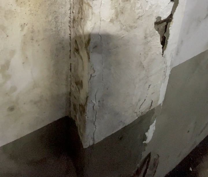 Canto de parede com fissura, manchas de umidade e pintura descascando